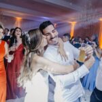 A cheerful moment captured during a lively wedding celebration with a dancing couple and guests.